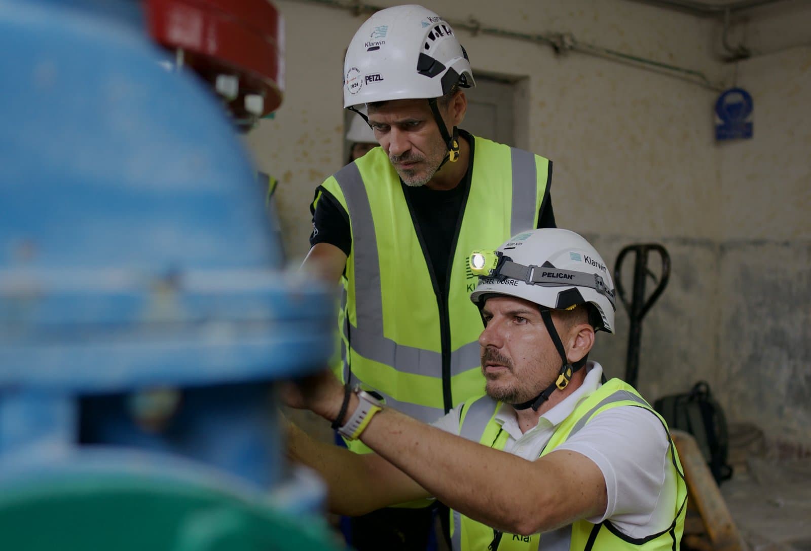 Doi ingineri Klarwin verificând o vană înainte de o operațiune de flushing industrial