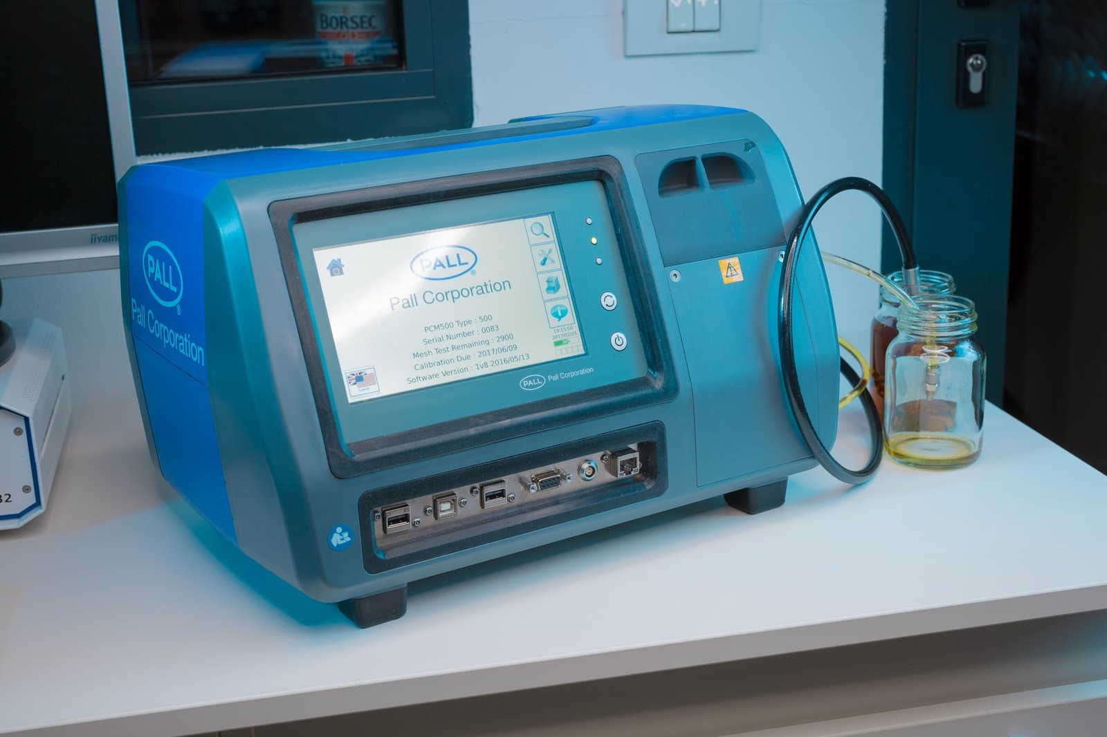 Numărător de particule Pall PCM500 pe masa de lucru a laboratorului Klarwin, conectat la o probă de ulei pentru analiză