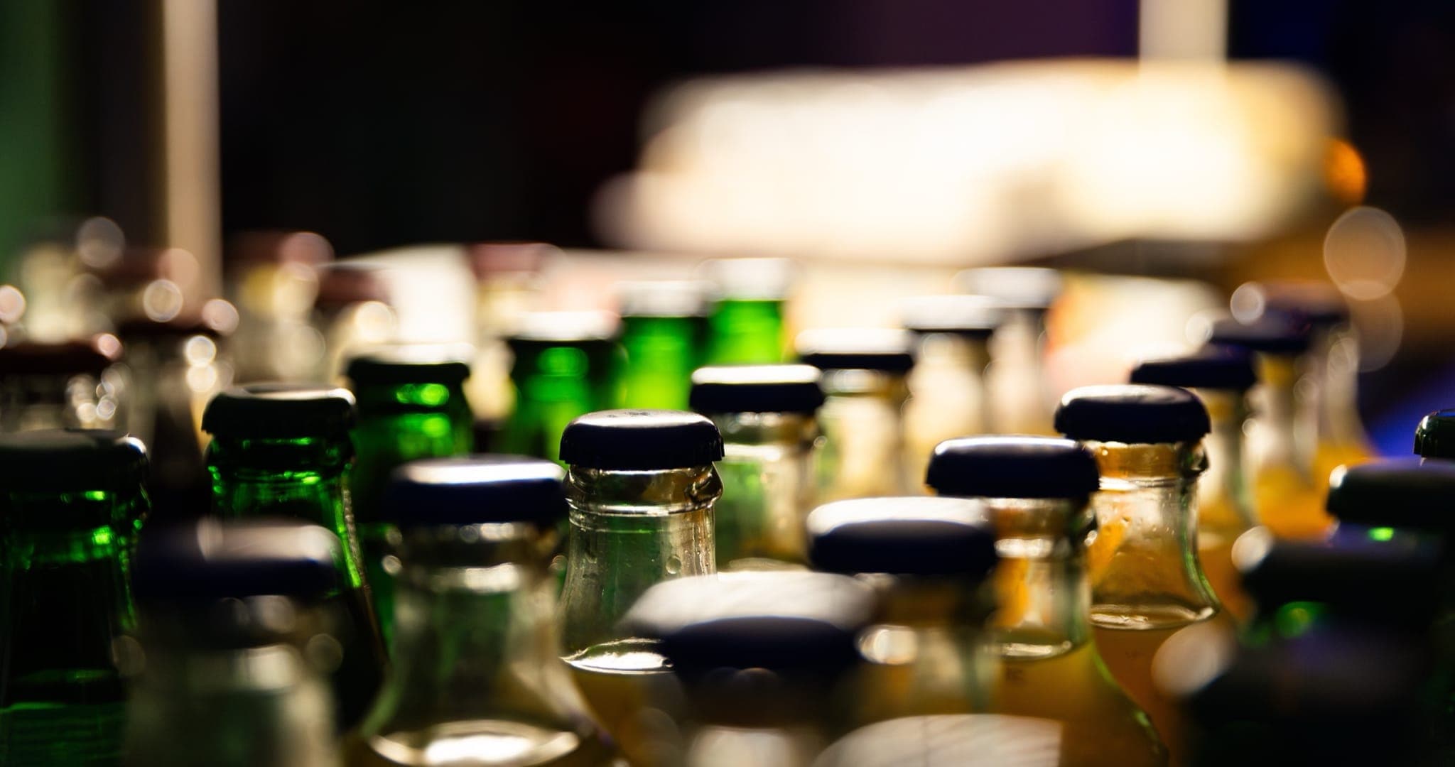 Filled and capped beverage bottles on a production line — the endpoint of a four-stage filtration process