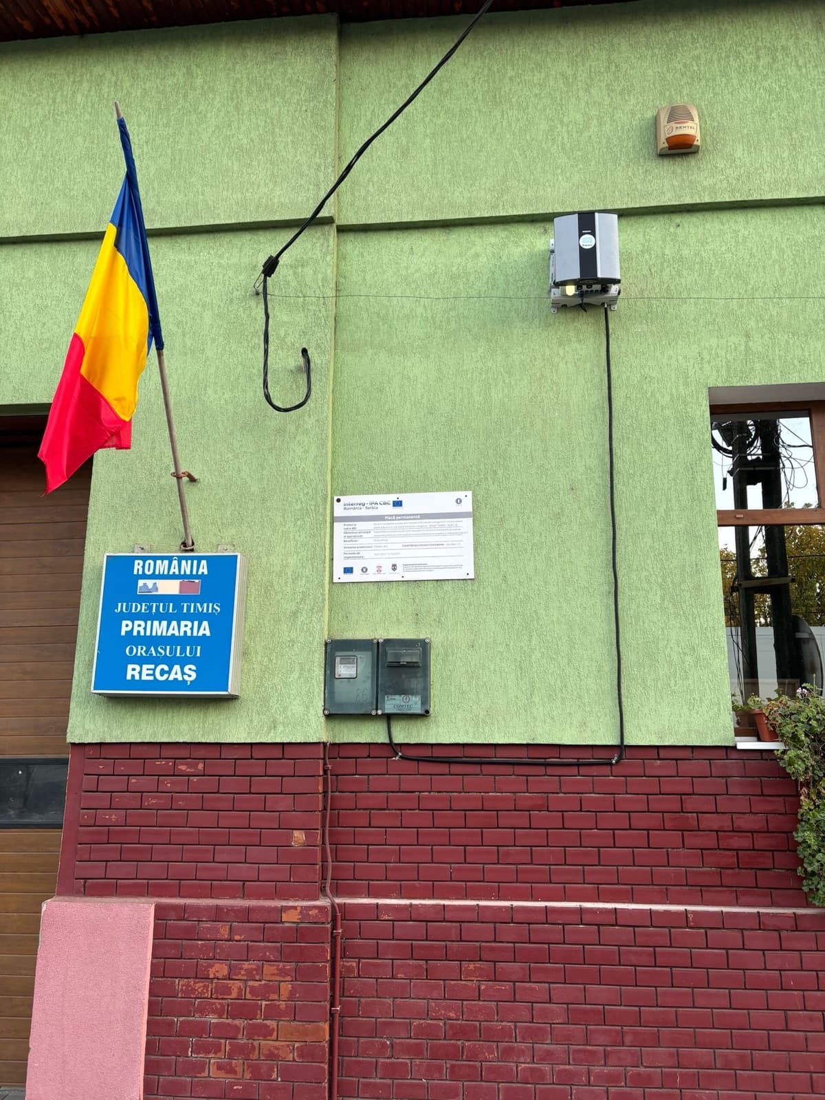 An Oizom Polludrone station mounted on Recaș Town Hall, beside the EU-funded Blue Sky project plaque