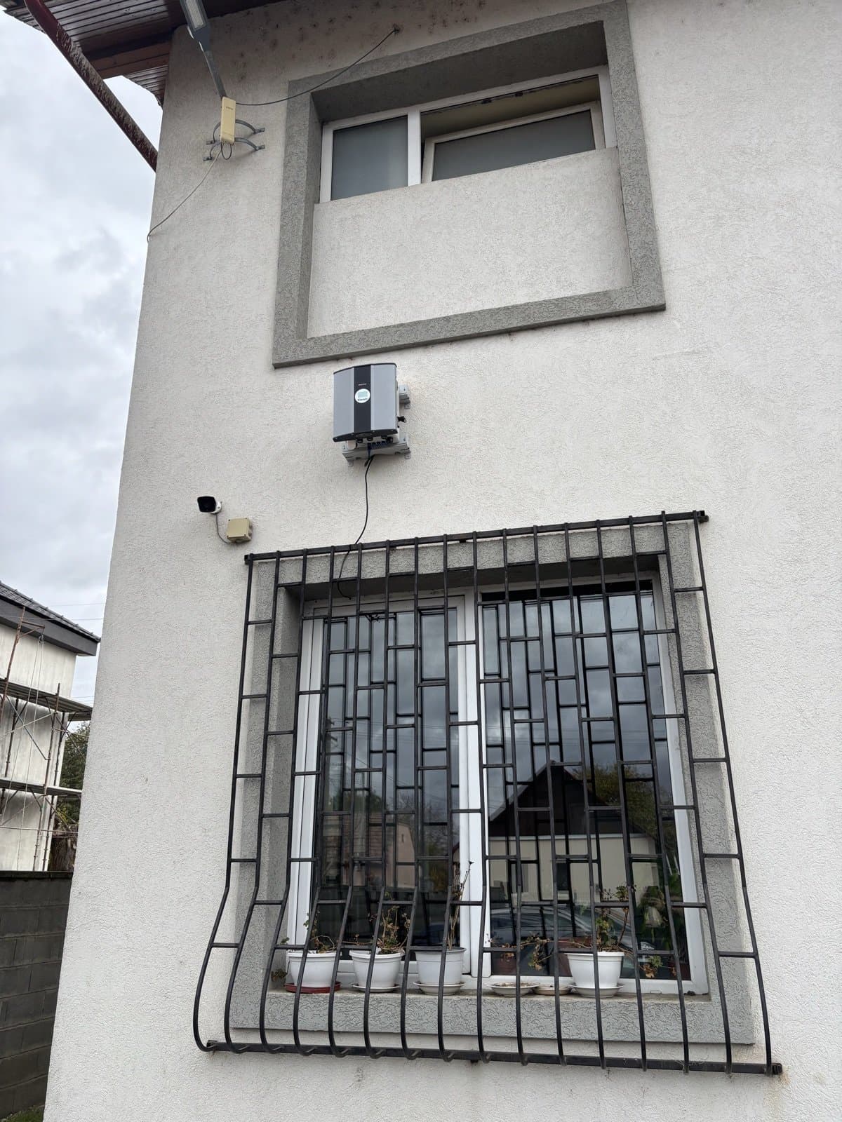 Polludrone air quality station mounted on a building wall beside a barred window