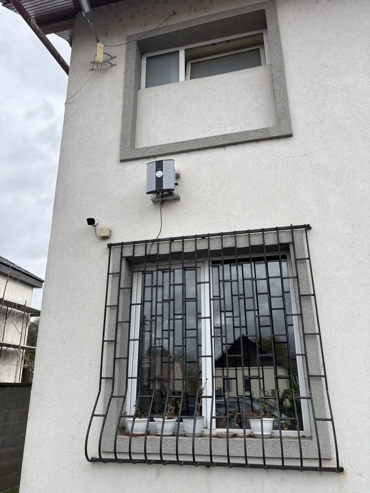 Polludrone air quality station mounted on a building wall beside a barred window